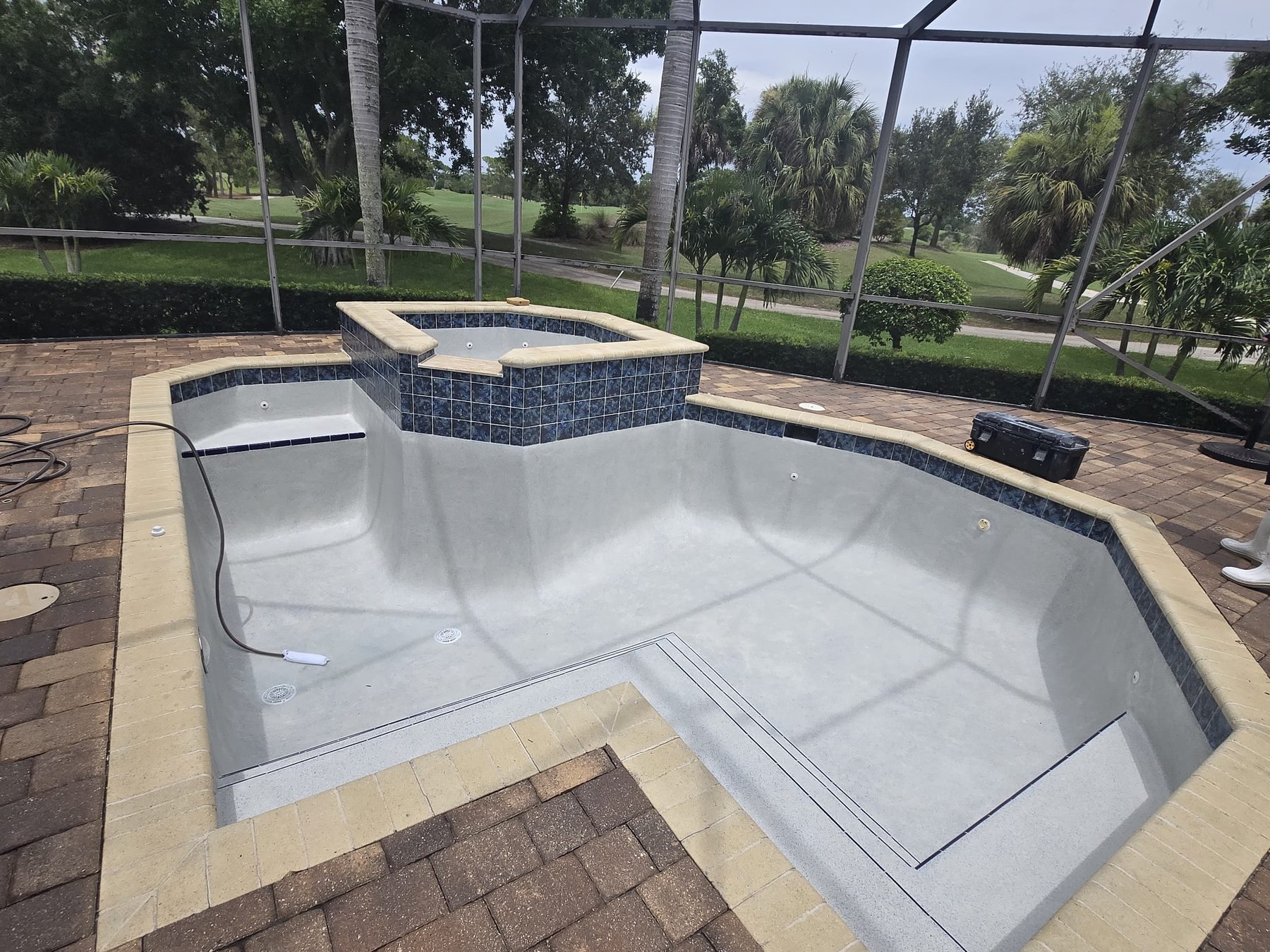 Freshly resurfaced pool and spa with new tile, ready to fill